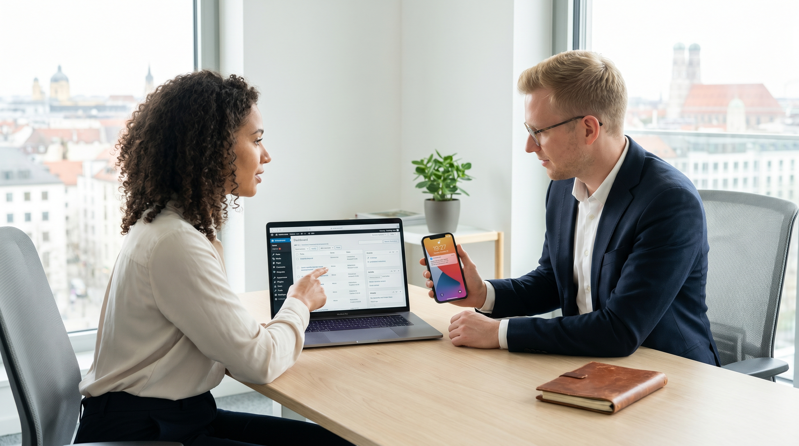 CMS-ADMINS-IT-Spezialisten beim Setup-Termin mit Kunde Smartphone und Laptop in Münchner Büro