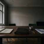 Walnussschreibtisch im Münchner Altbau-Büro mit Layout-Skizzen und Lederportfolio, Frauenkirche durchs Fenster