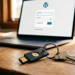 YubiKey 5 am Schlüsselbund vor Laptop mit WordPress-Login-Maske. FIDO2-Hardware-Login